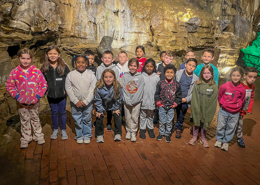 Students pose for photo in cave