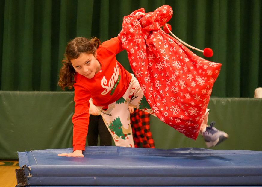 Student jumping with sack