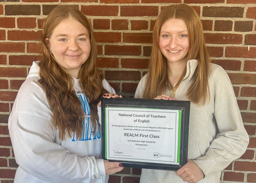 Students pose with plaque