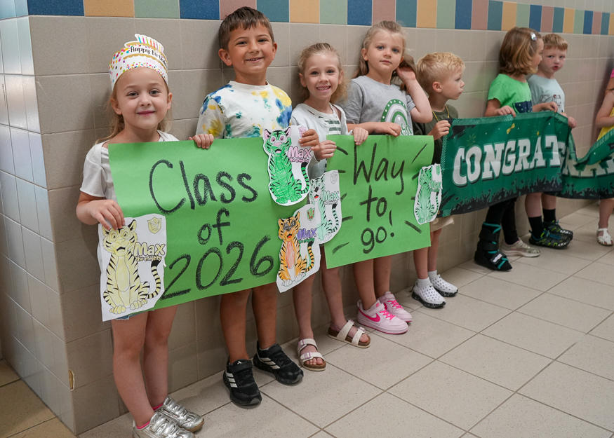 Students hold sign in hallway