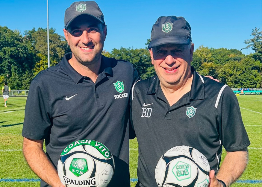 Coaches pose for photo with game balls