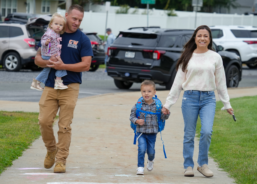 Family walks on sidewalk
